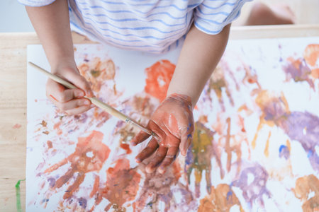 Cute asian girl smile play on school or kindergarten yard or playground. Healthy summer activity for children. Little asian girl climbing outdoors at playground. Child playing on outdoor playground.の写真素材