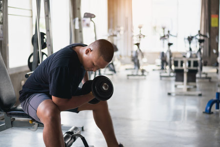 Sport man using dumbbell exercise at gym. Asian body building for muscle training.  Sport health gym...
