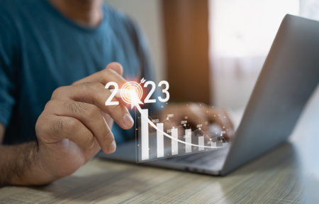 Business man using laptop point digital white pencil on virtual screen goal 2023 trade stocks or...