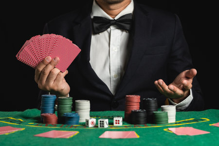 Crop picture of close up man dealer or croupier shuffles poker cards betting in casino on black background of green table, Dealer man invitation bet playing cards. Casino, poker, poker game conceptの写真素材