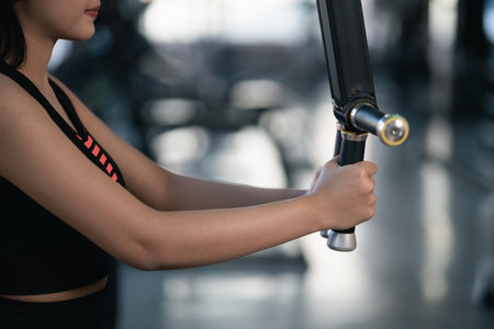 Asian sport women exercise wieght training and  workout dumbbell machine training at the gym. athlete girl training strong and good health and strengthの写真素材