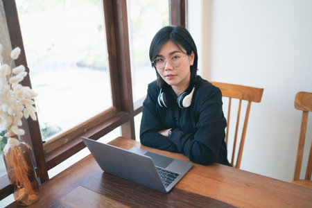 Business freelance entrepreneur woman with white headphone working typing keyboard on laptop and on...
