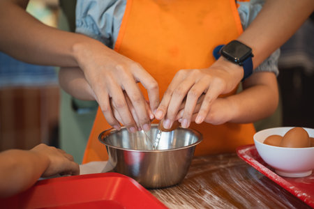 Asian girl learning to bake cake and cracking eggs cake Ingredients. Baking fun. This adorable baby girl learns to crack eggs, mix ingredients, and create a delicious cake with sprinkles and frosting.の写真素材