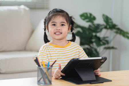 Asian girl looking and touch on white screen at the tablet screen attentively. overstimulated...