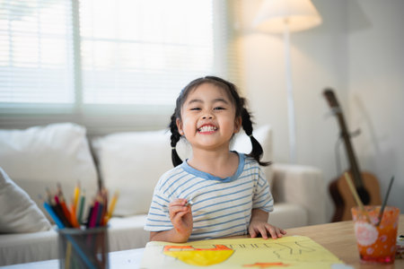 Cute little asian baby smiling painting with colorful paints using watercolor. Asian girl using paintbrush drawing color. Baby activity lifestyle concept.の写真素材