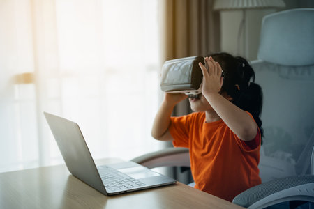 Asian girl children smile and play VR game, 3D divice new innovation glasses virtual screen AI technology for entertain at home, Girl joyful in house. Metaverse VR technology concept.の写真素材