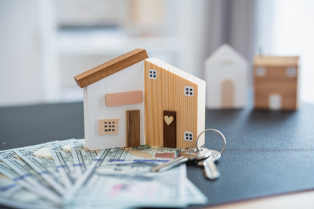 Home loan concept. House model on a table as a real estate agent and customer discuss contracts for buying, insuring, financing the property. Loan finance economy commercial real estate investments.の写真素材