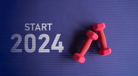 Happy new year 2024,2024 symbolizes the start of the new year. Top view of blue sport mat and pink dumbbells at gym fitness. Flat lay of small dumbbells on the mat. Fitness gym healthy and sport.の写真素材