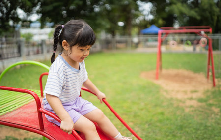 Cute asian girl smile play on school or kindergarten yard or playground. Healthy summer activity for...