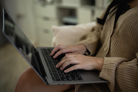 Top view. Asian freelance woman smile lying relax and typing on keyboard and working on laptop on sofa couch. Entrepreneur woman working for her business at living room home. Business work home.の写真素材