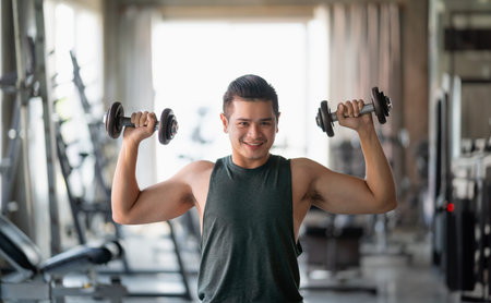 Asian sport man using dumbbell exercise at gym. Asian body building for muscle training. Sport...