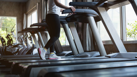 Close up of feet, sportman runner running on treadmill in fitness club. Cardio workout. Healthy...