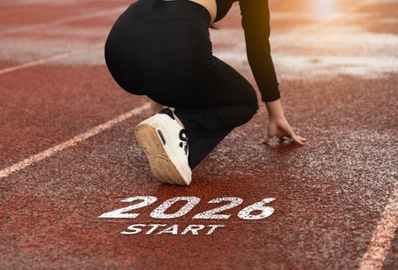 Athletic athlete prepares to sprint from starting line marked START on outdoor track, demonstrating focus and determination in a competitive environment.の写真素材