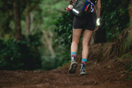 Woman Hiking on a Forest Path with Colorful Socks, Nature Trail Adventure, Outdoor Exploring, Fitness Journey in Lush Greenery Settingの写真素材