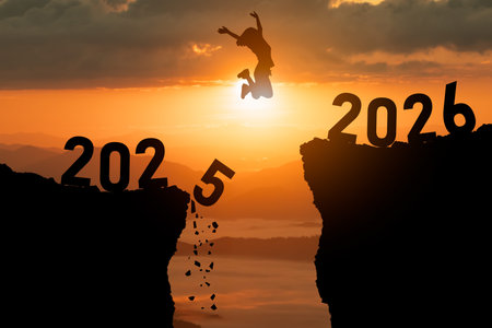 Person jumps over a gap between two cliffs representing year transition from 2025 to 2026, capturing...