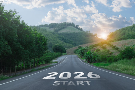 A picturesque empty road leads into the future. Framed by verdant hills and a vibrant sky, this image symbolizes new beginnings.の写真素材