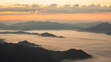 Serene Sunrise Over Misty Mountain Range with Vibrant Colors and Soft Clouds in the Sky, Capturing...
