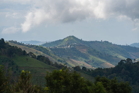 Scenic Mountain Landscape with Lush Green Valleys and Dramatic Cloudy Sky in Rural Nature Setting