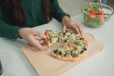 Delicious freshly baked pizza with melting cheese and assorted toppings, enjoyed by a person in a...