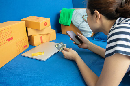Close-up shot of the teenage shopper is laying down on the sofa, and shopping online via smartphone...