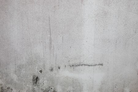 The white walls that have been left outside of the house for a long time show cracks, scratches and water marks. It looks empty and lonely, but beautiful and natural, suitable for making background and backdrop.の写真素材