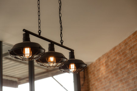 Vintage dome light using filament tungstain gives a warm orange glow in a restaurant decorated with...