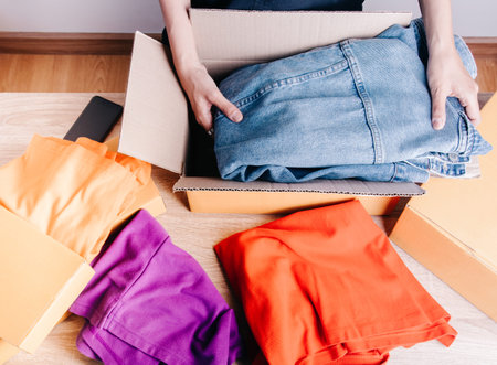 Top view shot of merchandise table with a lot of colorful clothes, jacket jean and boxes for...