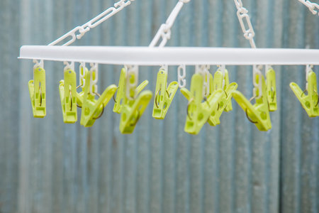 Selective focus and close up shot with copy space of cloth hanger with clips in the house on blurred...