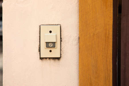 close up and front view of bell or buzzer is on the plaster wall in entry front of the house for security and safety to the resident. The copy space with blurred background is shown.の写真素材