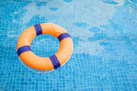 Top view and close up with copy space of orange swim ring for lifeguard and safety on the clear...