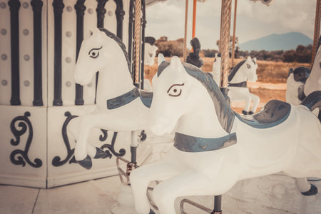 Vintage white carousel horse was abandoned in near urban area. It reminded the childhood happiness which children can play in festival or funfair during holiday, and now it is just memorial antique.の写真素材