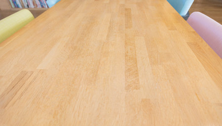 Top view and selective focus with perspective view of long wooden table with colorful chairs and...