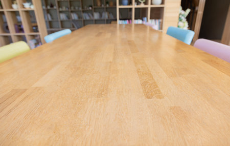 Top view and selective focus with perspective view of long wooden table with colorful chairs and design in relaxing atmosphere for business, working or meeting in shows beautiful for background.の写真素材