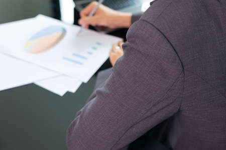 Close up desktop of young and smart business woman manager who is working on data analysis and computer laptop in office to make strategic plan for target achieving in business growth.の写真素材