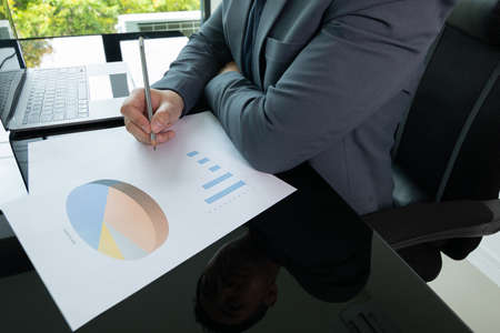 Close up working desk of young businessman manager who is working in professional career for analysing data and information to make strategic plan in sale, marketing and business growth.の写真素材