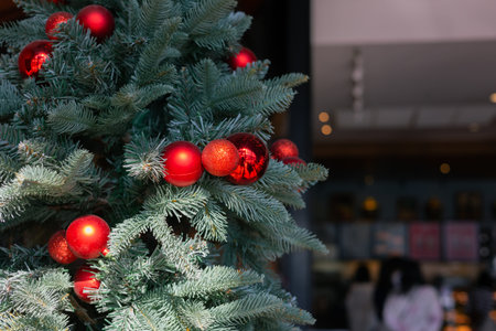 Close up Christmas tree with decoration on red and sparkling ball with copy space of blurred...