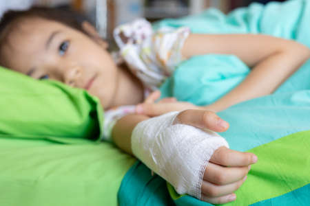 Selective focus of beautiful and adorable face of 5 years old kid asian girl who is sick due to virus infection and receive medication in hospital shows upset and worry for her disease on her bed.の写真素材