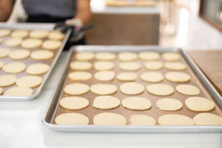 Selective focus and blurred background of beautiful bright and white decorative bakery kitchen with people or chef is working to prepare dough for making fresh dessert and bread for lunch or dinner.の写真素材