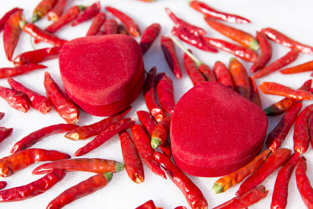 Red chili and heart shaped jewellery box in the snowの写真素材