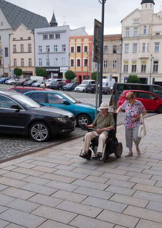 Olomouc, Czech Republic - July 17, 2021: Disabled man on wheel chair and his wife as an assistantのeditorial素材