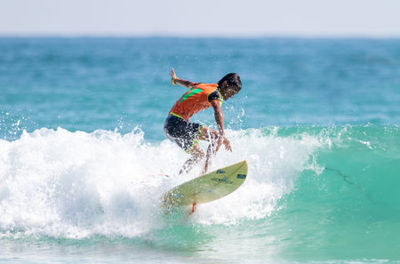 PHUKET - JUN 06: unidentified surfer in action catching waves in rainy season at Kata beach Phuket...