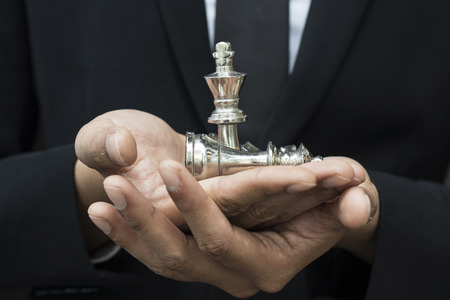 business man leader of a successful business holding the chess in handの写真素材