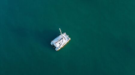 The drone captures a high angle view of catamaran sailboats moored in a tranquil bay.の写真素材