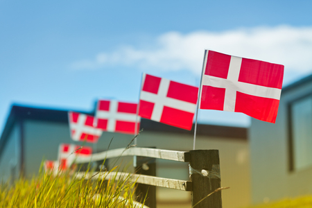Danish flags in a row on a wooden fence in a villageの写真素材