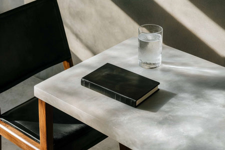 Journal on marble table with glass of water casting shadows, modern minimalism, AI generatedの素材