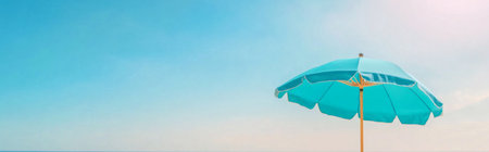 Beach umbrella on sandy beach under clear blue sky, summertime relaxation background, AI generatedの素材