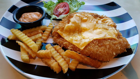 Golden Chicken cheese in black and white ceramic dish plate.