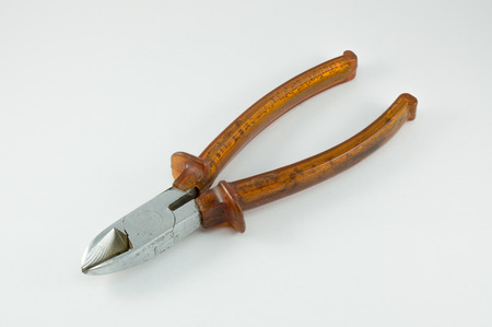 metal pincers with yellow plastic holder isolatedの写真素材