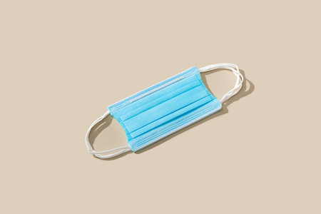 Flat lay composition with protective blue face mask on color background