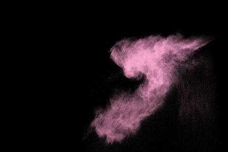 Pink powder explosion on black background. Colored cloud. Colorful dust explode. Paint Holi.の写真素材